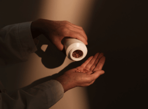 Frau hat Dose in der Hand und schüttet sich Pillen in Hand